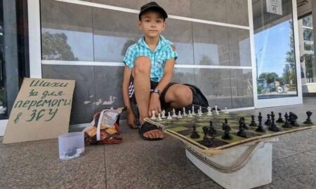 у центрі Нікополя  хлопчик пропонує зіграти перехожим у шахи і допомогти військовим