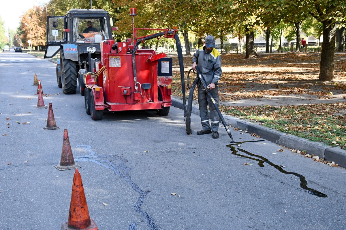 Попри обстріли у Нікополі комунальники ремонтують дороги, планують ґрунт, прибирають вулиці (фото)